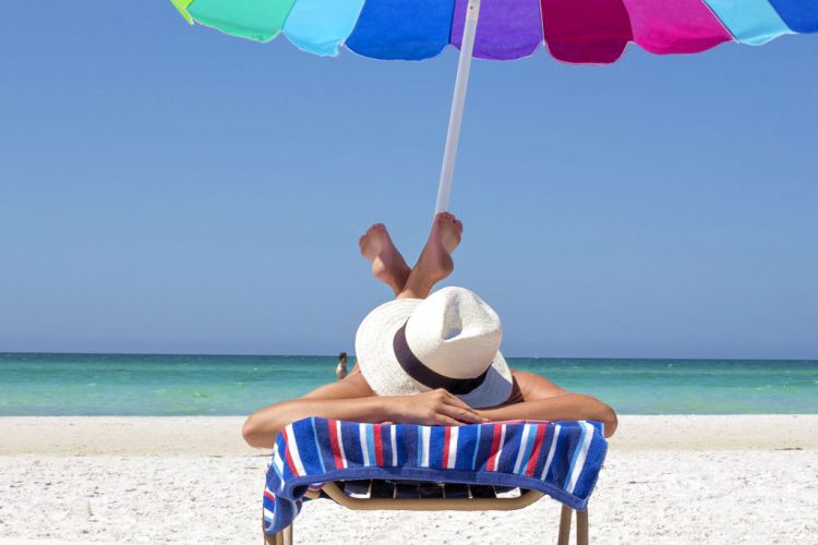 Eine Frau rekelt sich in der Sonne am Strand