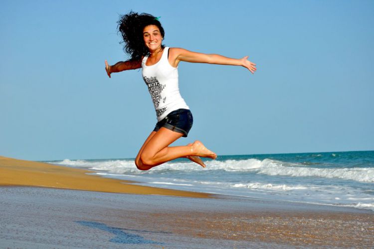Ein Mädchen springt auf einem Strand